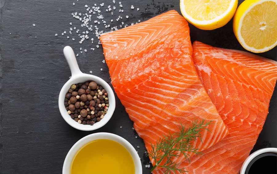 Raw salmon filet with lemon and olive oil