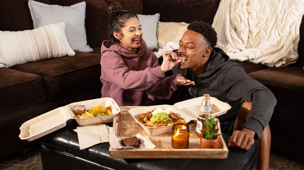 Woman feeding man nachos
